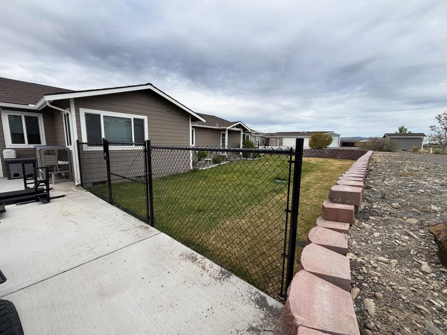Black chain link fence along a Columbia Basin backyard
