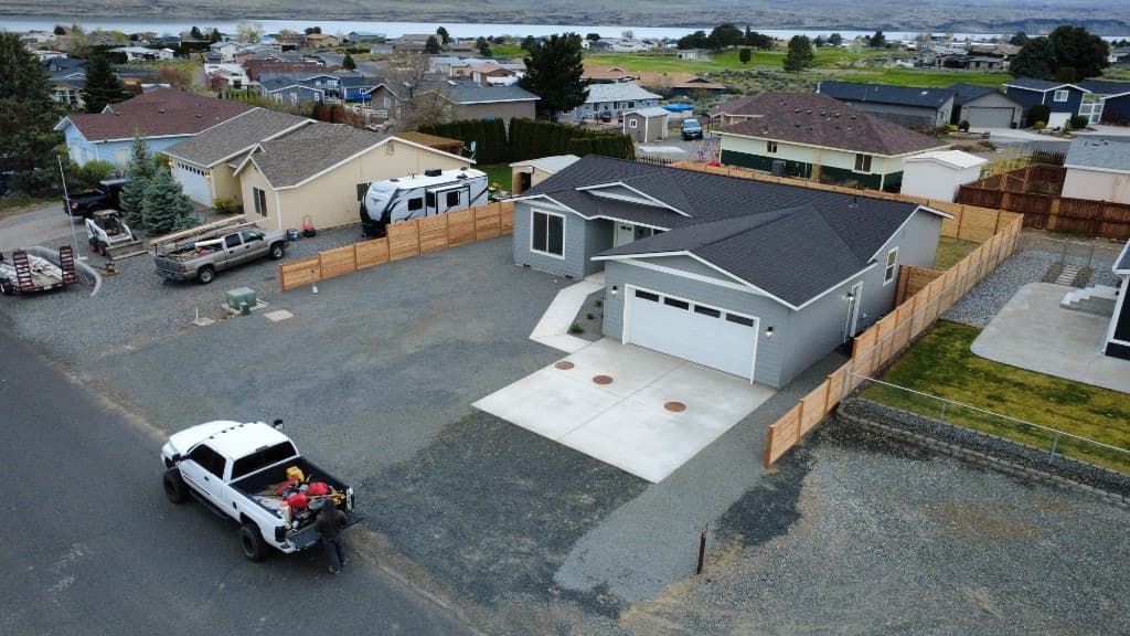 Drone view of home with new horizontal wood fence around gravel yard