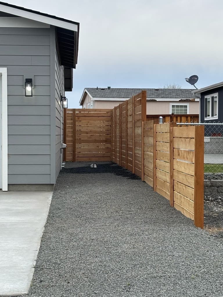 Horizontal wood slat fence with stepped taller section for privacy