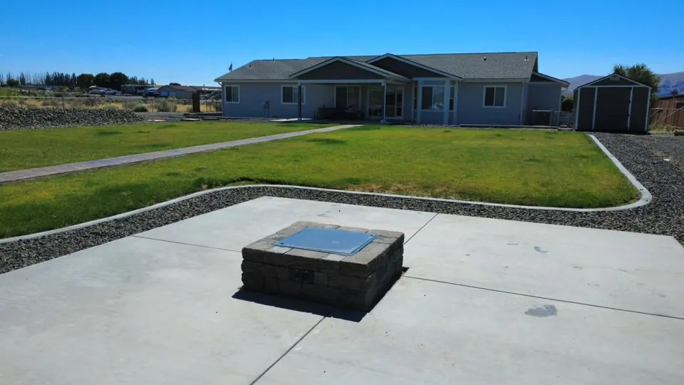 Finished fire pit, lawn, curbing, and decorative rock in Desert Aire